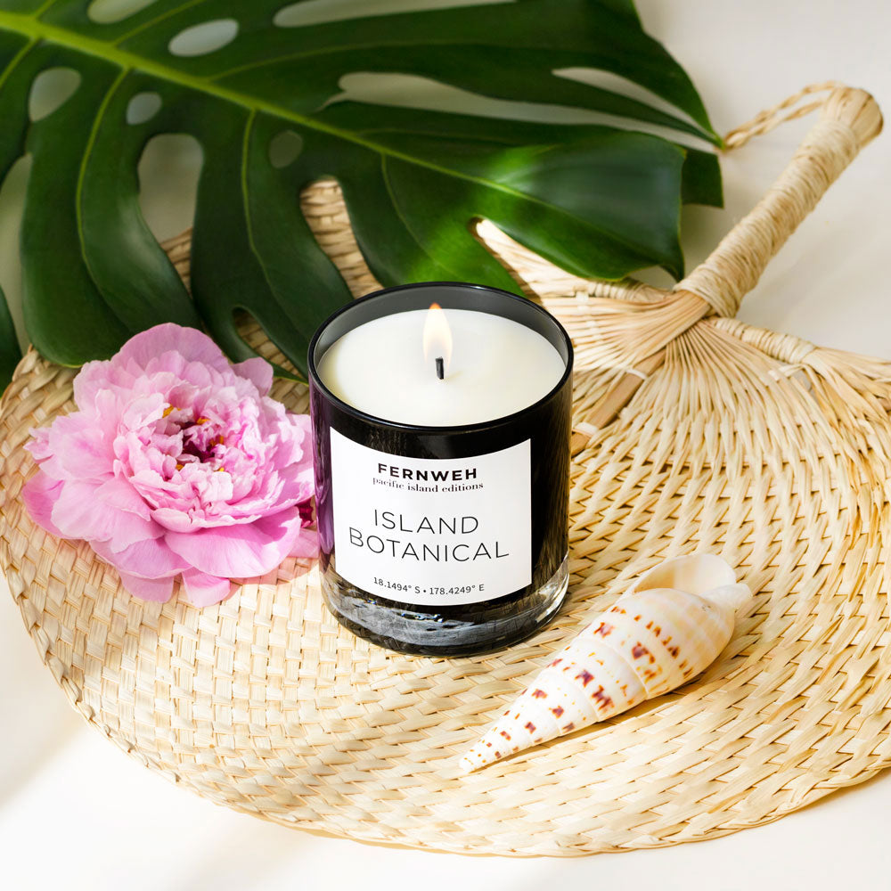 Lit Island Botanical soy candle with pink peony, monstera leaf and seashell