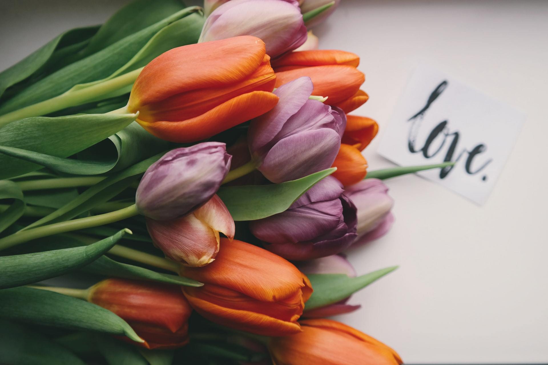Bouquet of orange and purple tulips with a handwritten love note