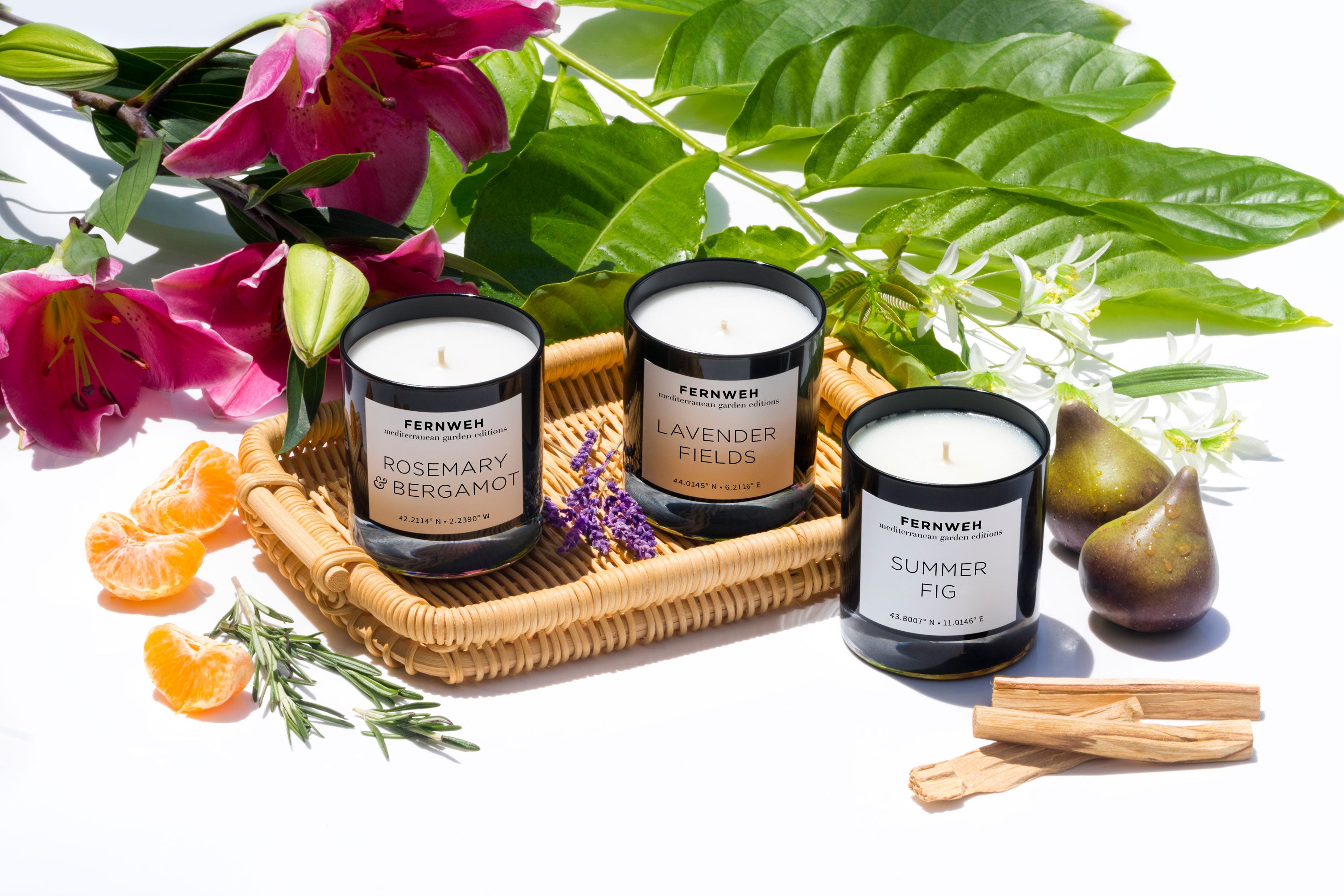 Three Mediterranean Garden soy candles on wicker tray with lily, figs and herbs